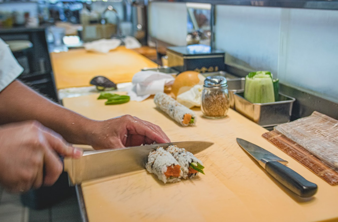 Chef cutting sushi rolls